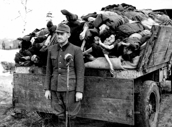 افسر نازی در کنار کامیونی از اجساد قربانبان اردوگاه کار اجباری در بلزن. 1945
